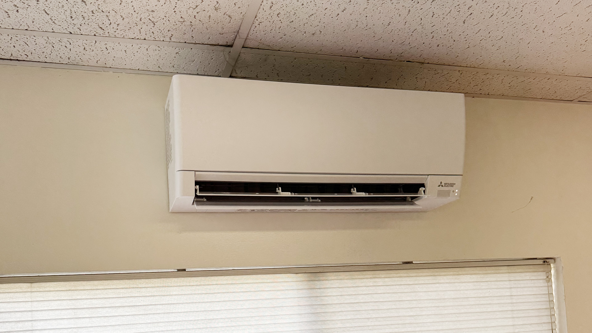 Indoor ductless ac air handler by Mitsubishi Electric, professionally mounted for zoned cooling by Arrow Appliance Heating and Air Conditioning.