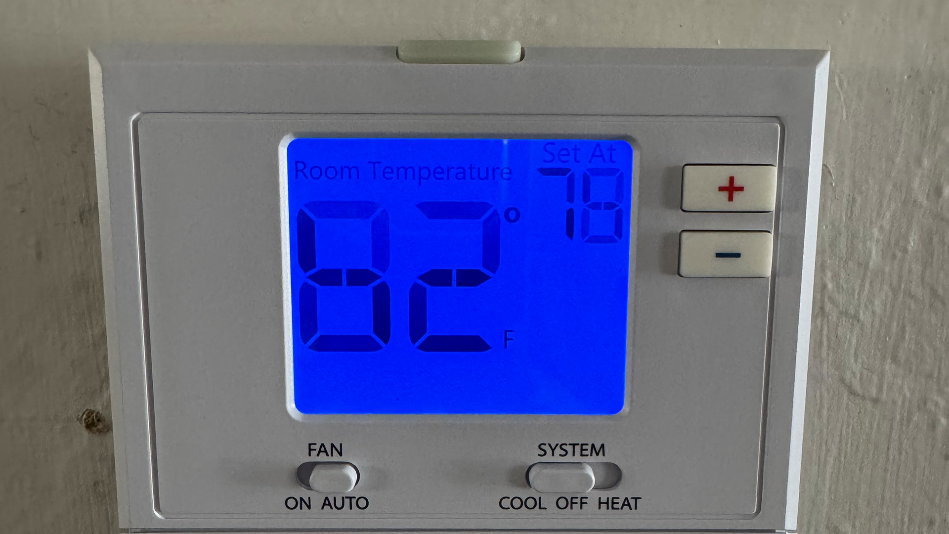 Modern digital thermostat showing 82 degrees with Arrow Appliance Heating and Air Conditioning service sticker for local AC repair.