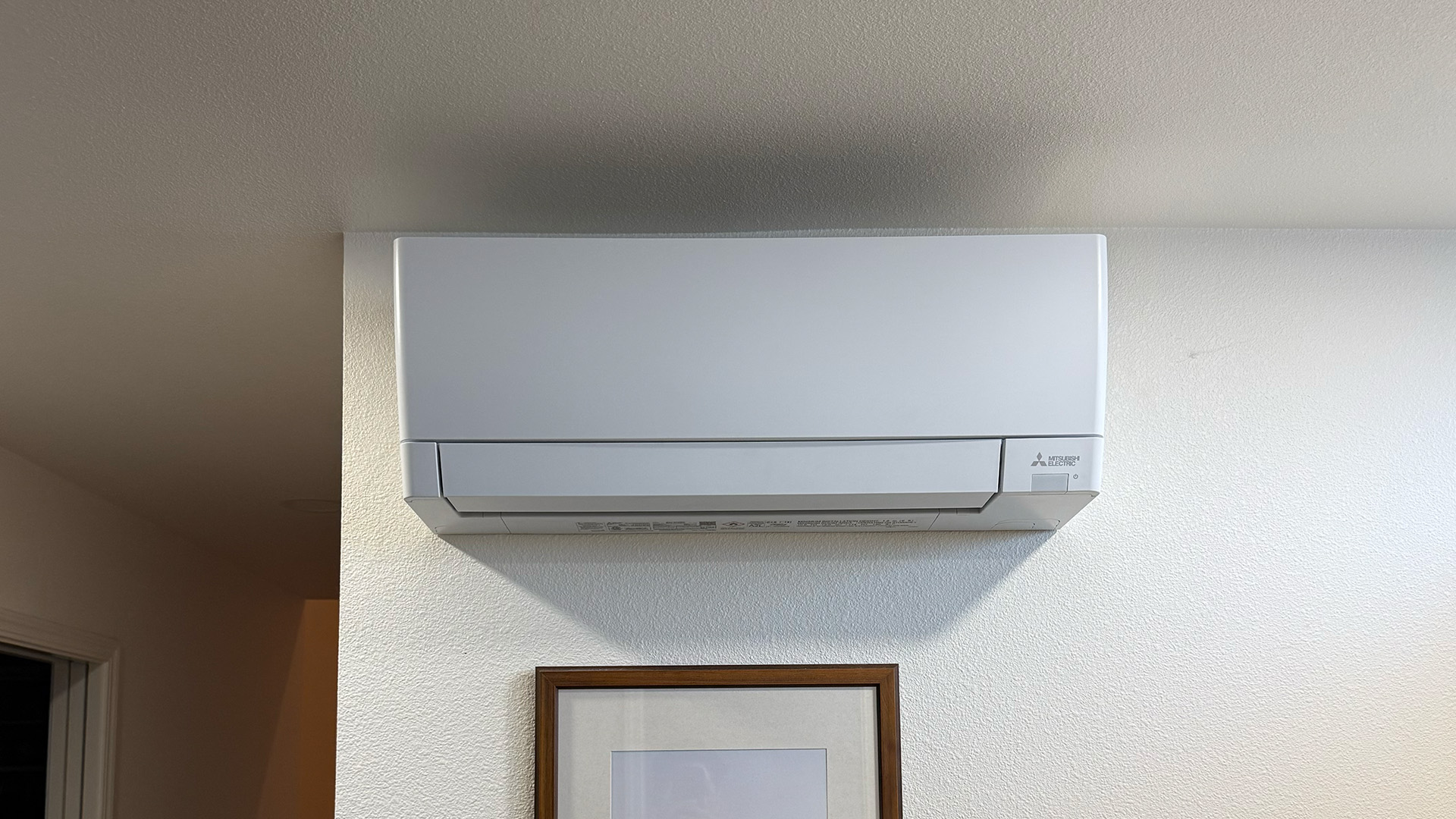 Wall-mounted Mitsubishi Electric indoor mini-split unit for quiet, zoned heating and cooling in a modern room.