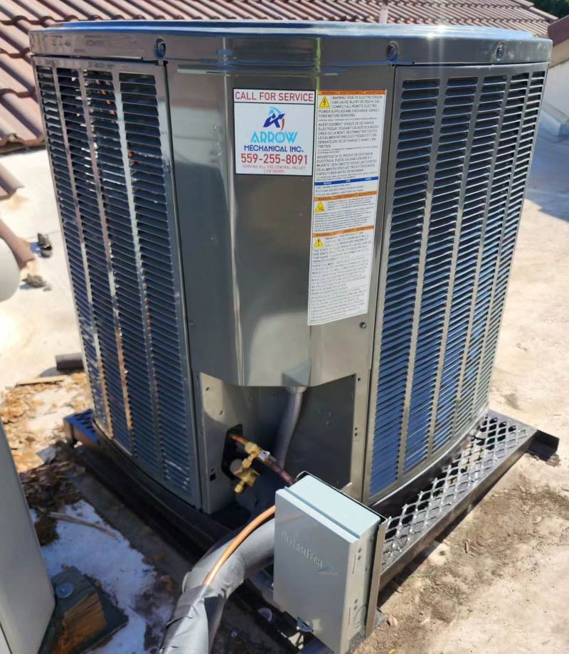 Close-up of a rooftop HVAC unit on a black metal platform featuring a prominent "Call for Service" sticker for Arrow Mechanical Inc. with phone number 555-255-8091.
