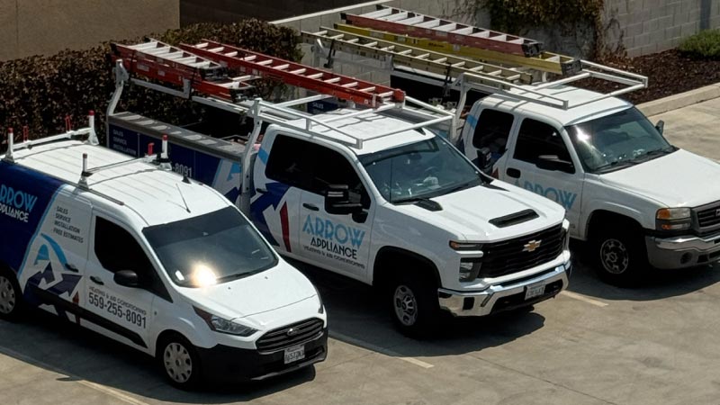 Fleet of Arrow Appliance Heating & Air Conditioning service trucks and vans equipped with ladders parked and ready for dispatch.
