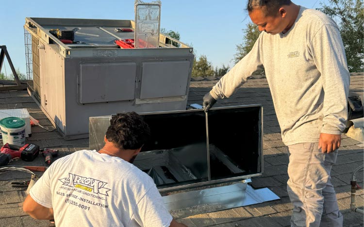 Arrow Heating and Air Conditioning technicians assembling an insulated sheet metal roof duct elbow on a residential rooftop.